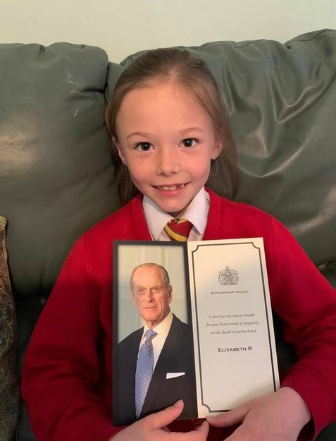 A smiling Ellie with her reply from Queen Elizabeth II