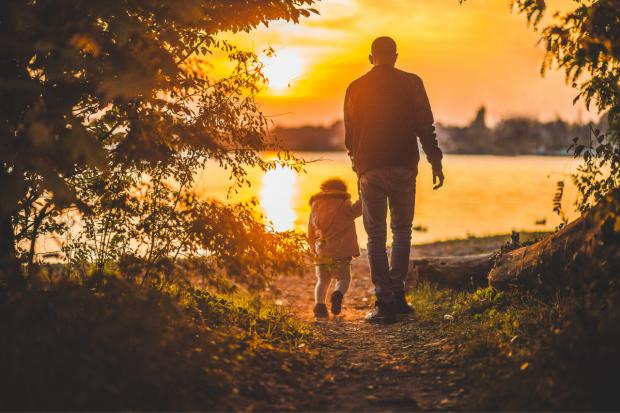 Barry And District News: Father and child walking together at sunset. Credit: Canva
