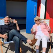 Larry Lamb and Alison Steadman on deck chairs outside the iconic Barry Island beach huts (Picture: Barrybados/Facebook)