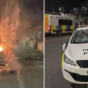 A car set alight and a damaged police car in Ely, Cardiff, as rioters clashed with police