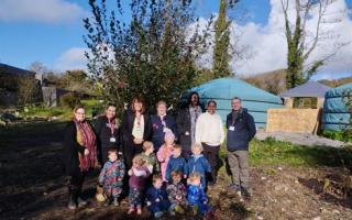 Cllr Rhiannon Birch (C) and Eddie Williams (R) with the nursery group at new outside space
